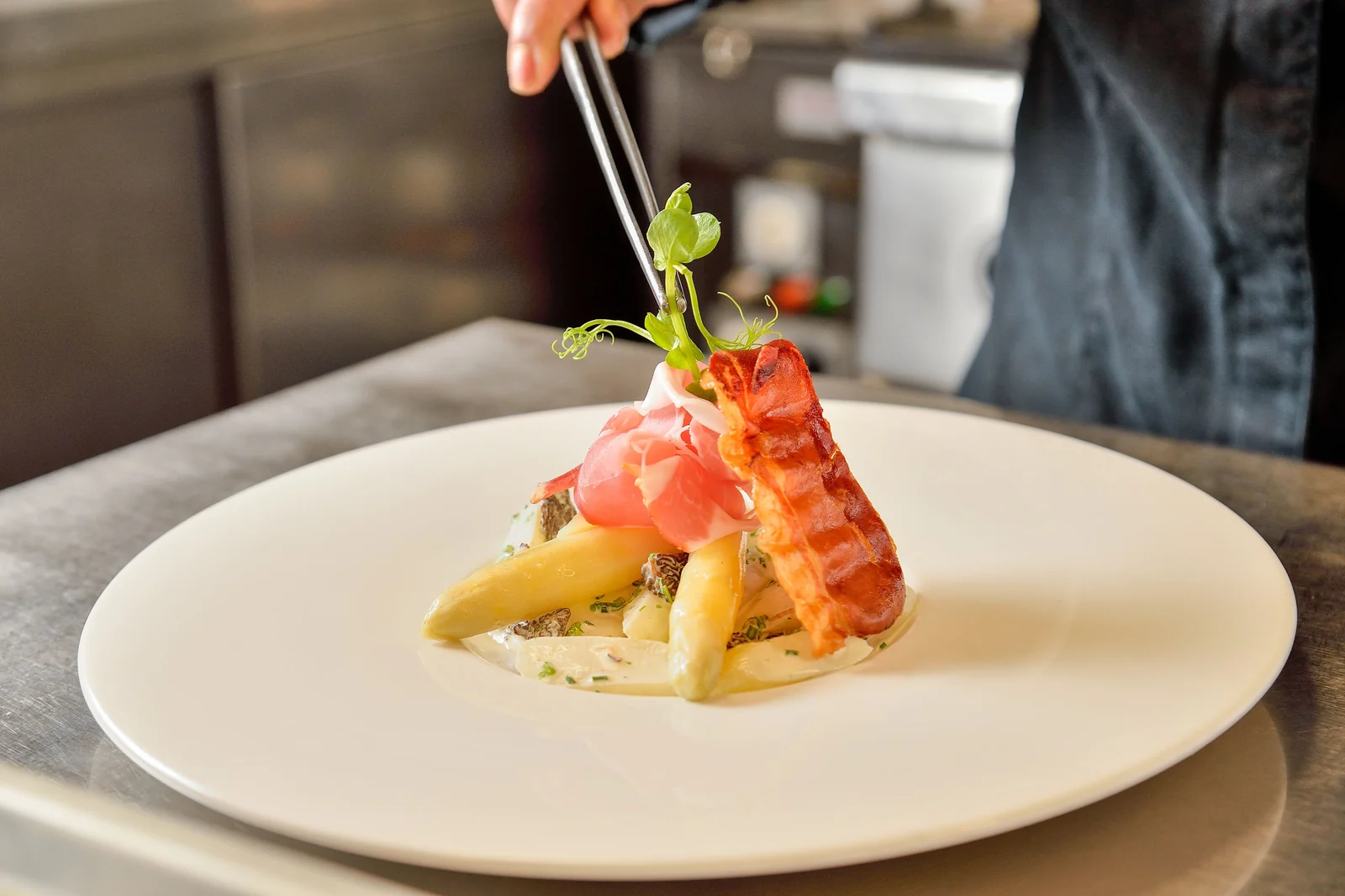 Dressage d’une assiette de poisson et de légumes dans la cuisine du Bistrot